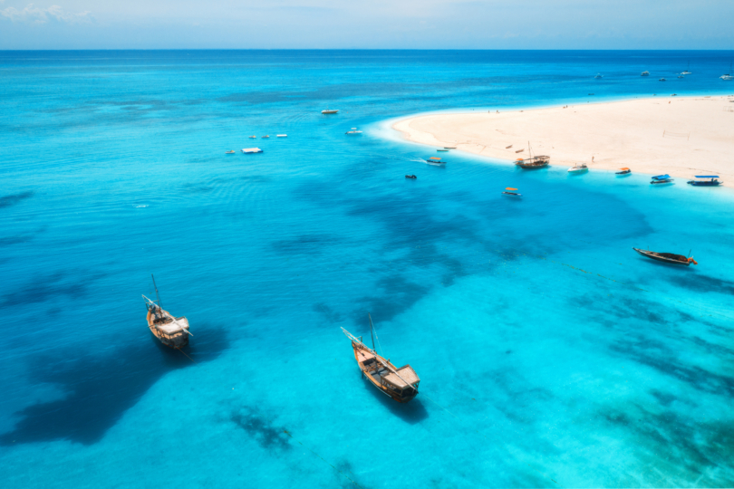 Aerial view of boats on tropical sea coast with sandy beach